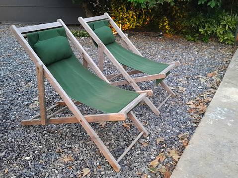Two green sun loungers are a bit worn out.