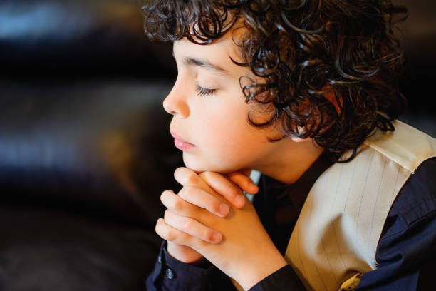 Christian boy with hands clasped.