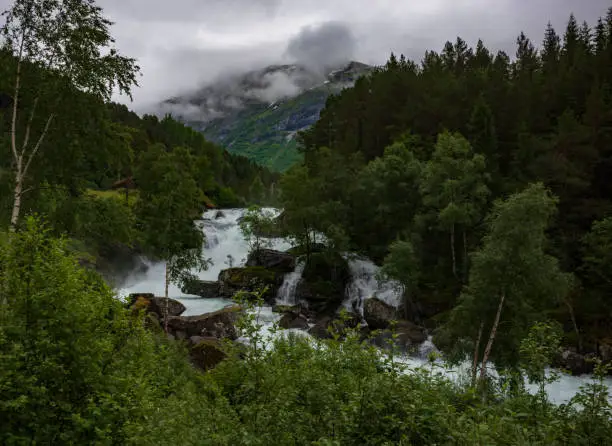 Rapids at a mountain creek flow along the Norwegian scenic route Gaularfjellet between Moskog and Balestrand during an overcast, stormy day.