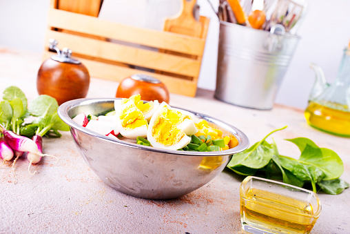 Bowl of vegetarian salad with boiled eggs- radishes- cucumbers- corn salad