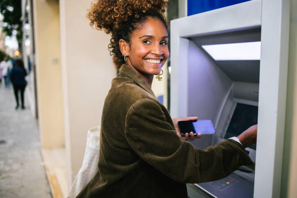 istock Happy Latin woman on a journey using the ATM 1763323979