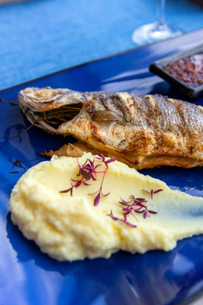 istock Seabass baked with vegetables, lemon and mashed potatoes on plate 1763324334