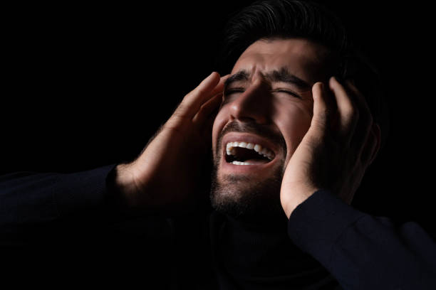 istock Stressed Young hopeless man screaming and shouting Frustrated handsome man agonizing and torturing expression He get maddening and overwhelming rage in the dark room black background Agressive man 1763324569