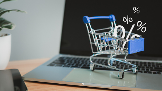 Sale percentage falling in shopping cart located on a computer keyboard, Online shopping concept Special price product, Specials and promotions