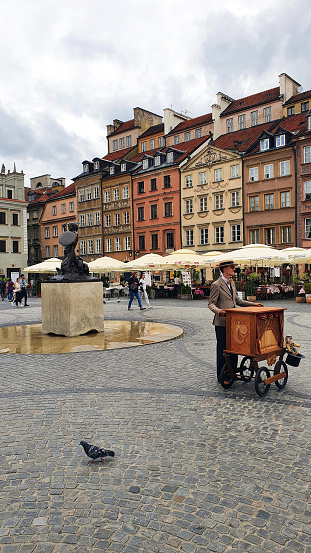 Warsaw, Poland - July 12, 2022: Colorful tenement houses on a cloudy day on the Old Town Square in Warsaw