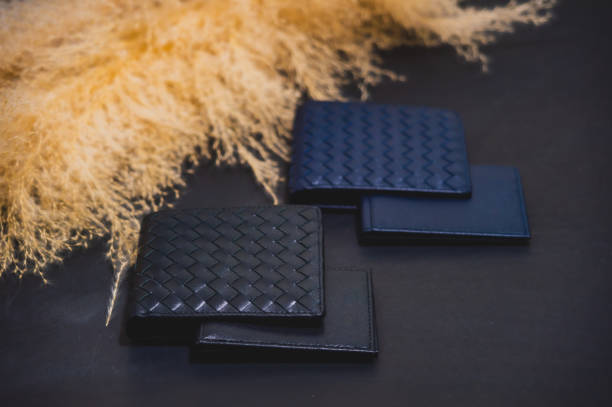 istock High quality genuine leather wallet Separated type, can hold cards inside, black background, with yellow dried grass flowers placed nearby. Studio Shot promotional product images 1763334293