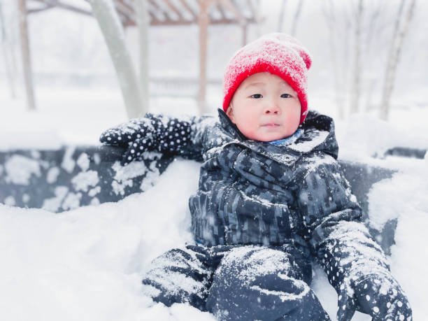 istock Cute little boy having fun and playing in playground during snowfall 1763338696