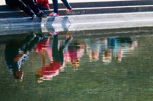 People reflected in a water surface