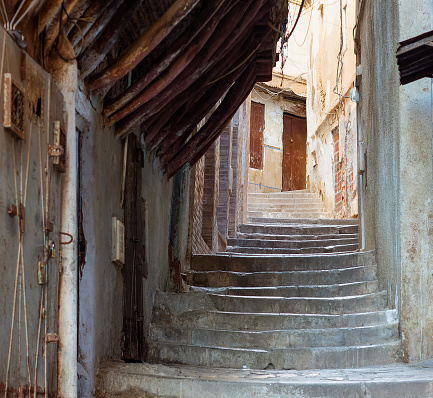 Street scene in the Casbah of Algiers (Alger), Algeria. Stone stairs and ancient ottoman houses. Narrow street. Typical wooden ottoman achitectural structure. Chiaroscuro atmosphere.