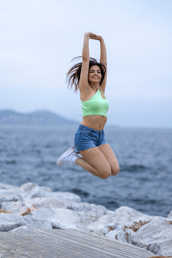 Young woman jumping by the sea