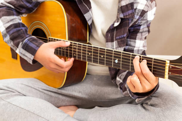 las manos de un niño tocando la guitarra. - 13 14 years teenager 14 15 years child fotografías e imágenes de stock