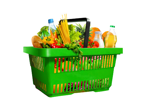 Plastic green shopping basket full of assorted grocery products isolated on white background