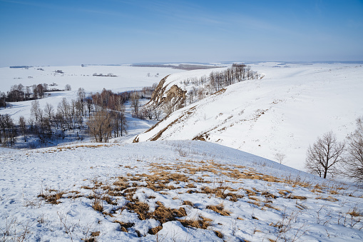 Hills covered with snow winter landscape, mountainous terrain, uneven terrain in winter, hiking in winter, nature of Russia, spring in the Southern Urals. High quality photo