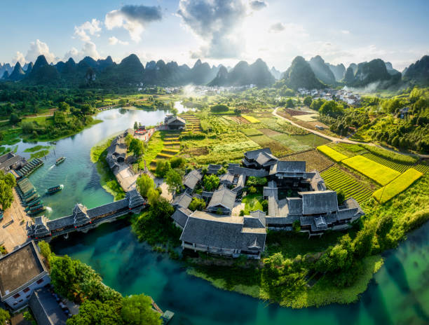 Shangri-la Gardens, Yangshuo, Guilin, China Aerial view of Shangri-la Gardens at sunset, boats in the river, rice fields and karst mountains in the background, Yangshuo, Guilin, Guangxi Province, China yangshuo stock pictures, royalty-free photos & images