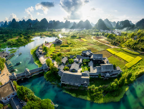 Shangri-la Gardens, Yangshuo, Guilin, China Aerial view of Shangri-la Gardens at sunset, boats in the river, rice fields and karst mountains in the background, Yangshuo, Guilin, Guangxi Province, China yunnan perspective stock pictures, royalty-free photos & images