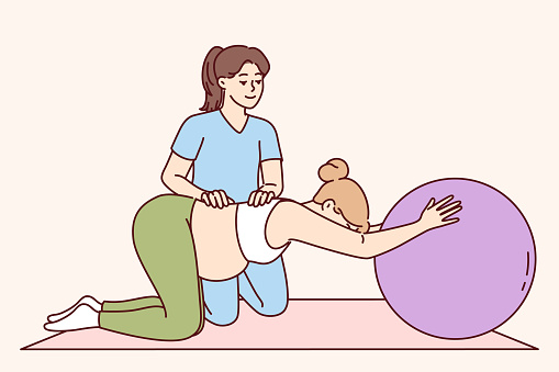 Gymnastics for pregnant women and physical exercise under supervision of physiotherapist to help prepare for childbirth. Pregnant girl doing pilates with big rubber ball to keep health in good shape