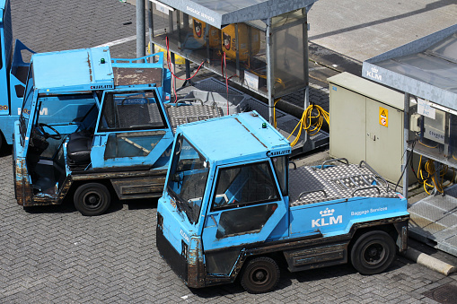 Schiphol, Netherlands - August 12, 2012: KLM Baggage Services TCR Charlatte baggage tractors at charging station at Amsterdam Airport Schiphol.