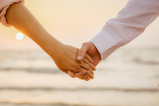 Cropped shot of a couple holding hands outdoors