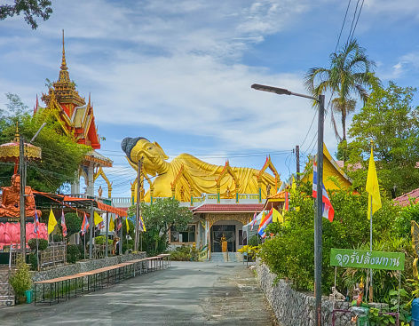Big lying golden Buddha statue at Wat Sri Sunthon temple by day, Phuket, Thailand