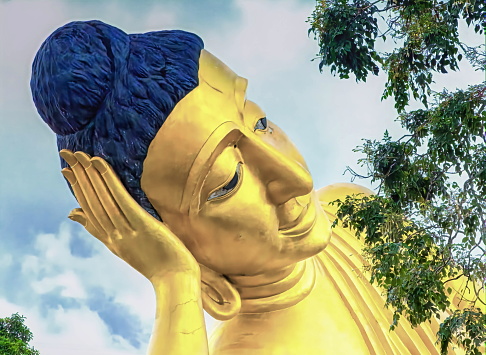 Head of big lying golden Buddha statue at Wat Sri Sunthon temple by day, Phuket, Thailand