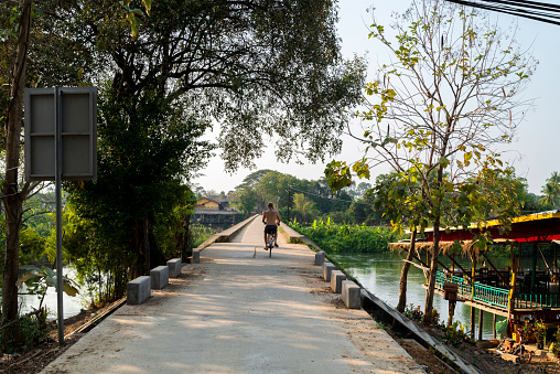 Looking towards Don Khon Island,along the French colonial bridge,a popular landmark and sunset viewpoint,for tourists to cross by foot or bicycle,or relax on as sun sets.