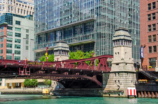 LaSalle Street bridgehouses and north leaf of bridge for the La Salle Street or Marshall Suloway Bridge. The bridge is a double-leaf trunnion bascule bridge crossing the Chicago River. Glass and steel skyscaper at 300 North LaSalle in background. Chicago, Illinois, USA.