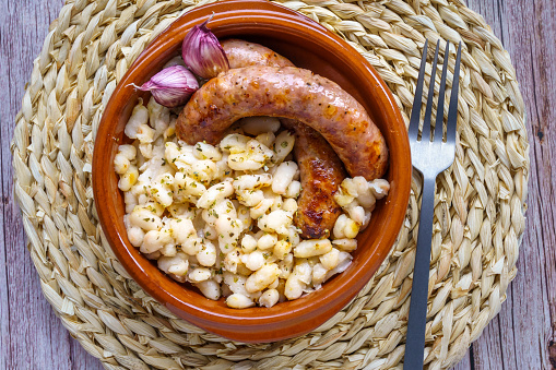 Earthenware bowl with botifarra de amb mongetas, white bean and sausage typical of Catalonia, Spain