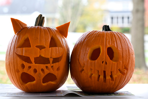 Carved Halloween pumpkins together on a table outdoors.