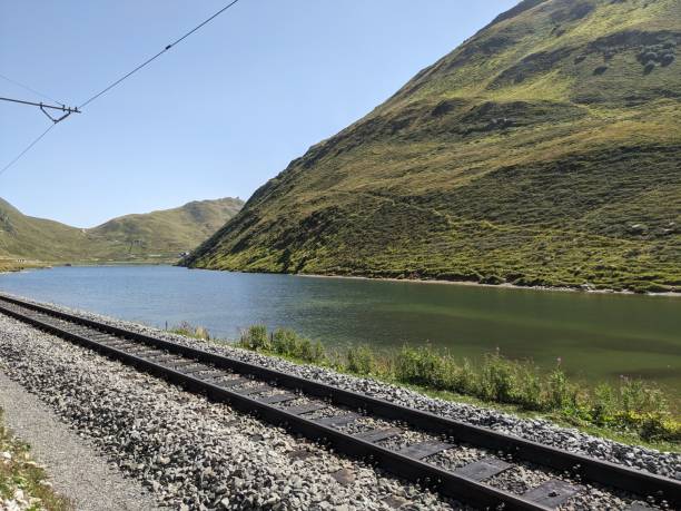 istock Train tracks next to a body of water 1763482118