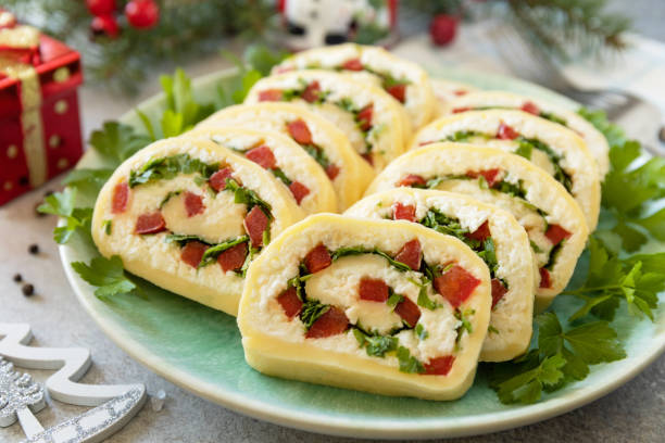 istock Creative appetizers christmas. Cheese roll with cream cheese, sweet pepper and greens. 1763513241