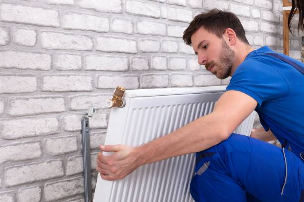 istock Repairman Installing Radiator On Brick Wall At Home 1763521205