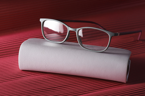 Stylish glasses for eyesight with elegant black grey on red background. Classic frame.