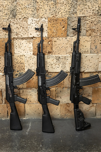 Rifles against the wooden wall in a shooting range, close up photo