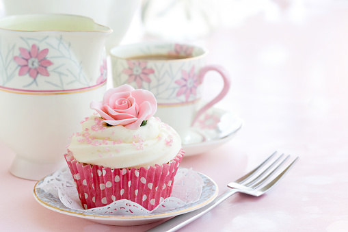 Rose cupcake on a vintage china plate for afternoon tea