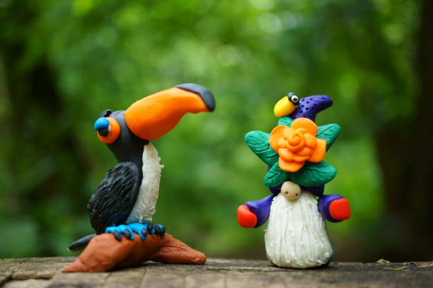 Toy bird toucan and a dwarf made of plasticine close-up.