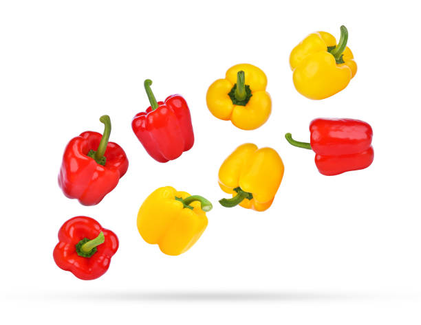 istock Whole red and yellow bell pepper falling in the air isolated on white 1763586283