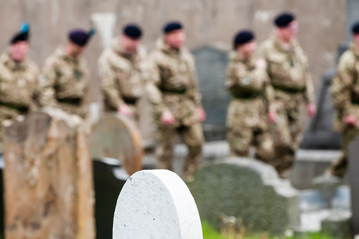 Carrickfergus, Northern Ireland. 23/05/2015 - Soldiers from B Squadron walk among gravestones in a graveyard on their way to the church service to mark the formation of Scottish and North Irish Yeomanry Regiment, a light cavalry regiment, and part of the British Army Reserves.  In 2014 the Royal Mercian and Lancastrian Yeomanry, the Queen's Own Yeomanry, Lothians and Border Horse, North Irish Horse, Ayrshire Yeomanry and the Fife and Forfar Yeomanry all merged to form the Scottish and North Irish Yeomanry Regiment, bringing together cavalry skills into a single unit.  In 2015 they officially entered service with the army, and were awarded the 