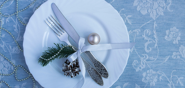 Christmas table setting on the blue textile background. Top view. Copy space.