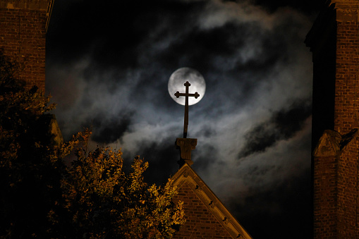 Rising full hunter's moon over the village Church