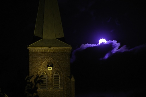 Rising full  moon over the village Church