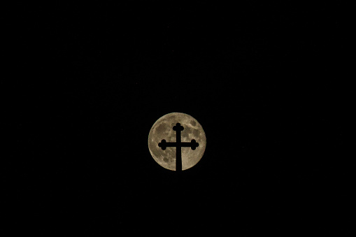 Rising full hunter's moon over the village Church