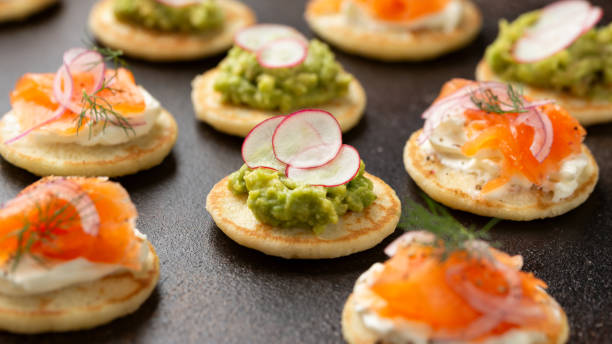 istock Mini blini pancakes with soft cheese, cold smoked salmon and guacamole 1763636836