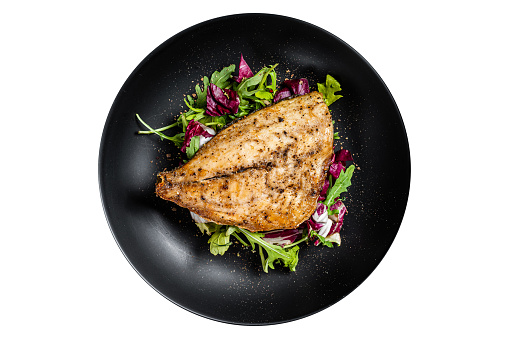 Grilled Sea Bream Dorado fillets served on fresh salad.  Isolated on white background