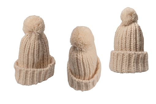 Beige beanie hat with pom pom isolated on a white background.