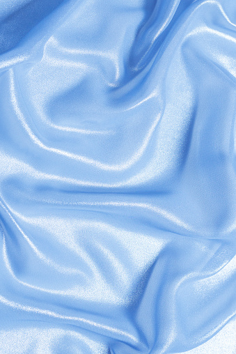 Blue shiny pearl fabric as a background. Top view.