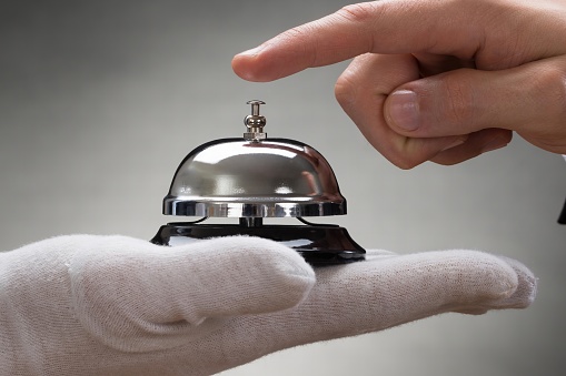 Close-up Of A Person's Hand Ringing Service Bell Hold By Waiter