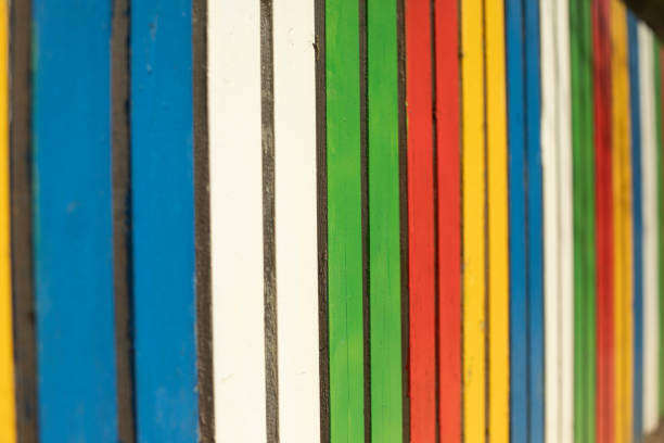Colored fence. Beautiful fence. Different color on boards. Painted material. Design Details.