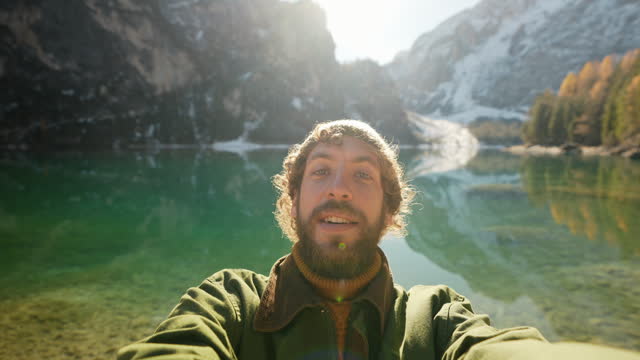 Selfie of man on the background of  Lago di Braies in winter