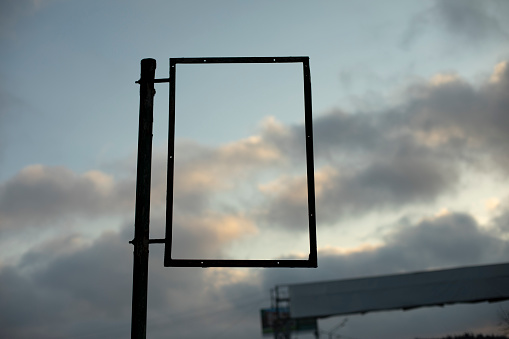 Empty frame against sky. Rectangle black. Picture insertion frame. Sign at bus stop.