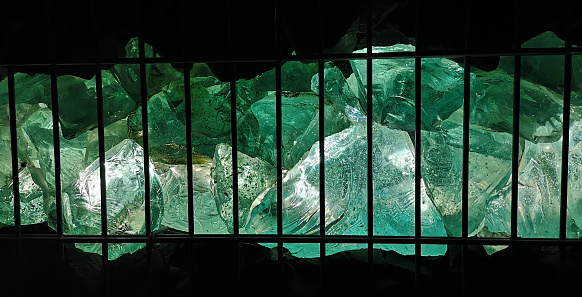 glass clumbs illuminated behind a grid
